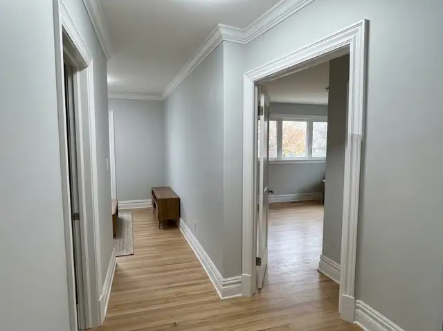 Hallway with new white door casing, baseboards and crown molding (illustration)